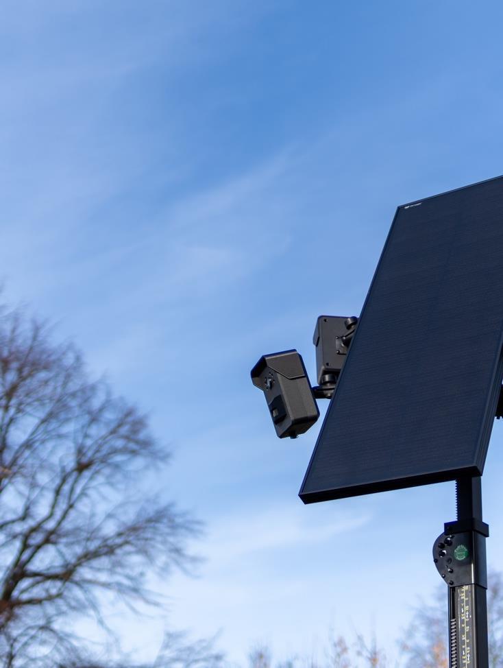 Solar-powered security camera system with Context AI against a blue sky.